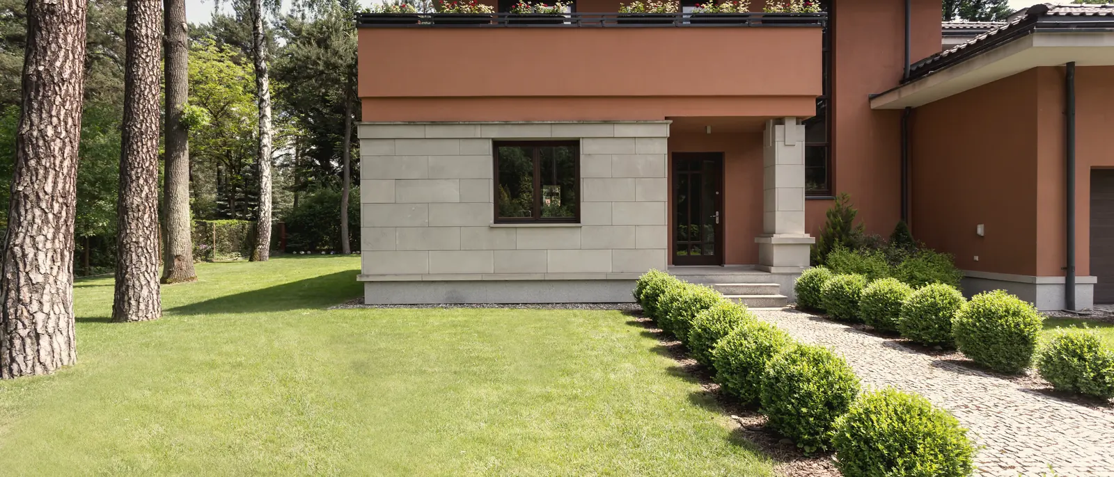 Maison contemporaine avec aménagement paysager haut de gamme : haies taillées et pelouse impeccable