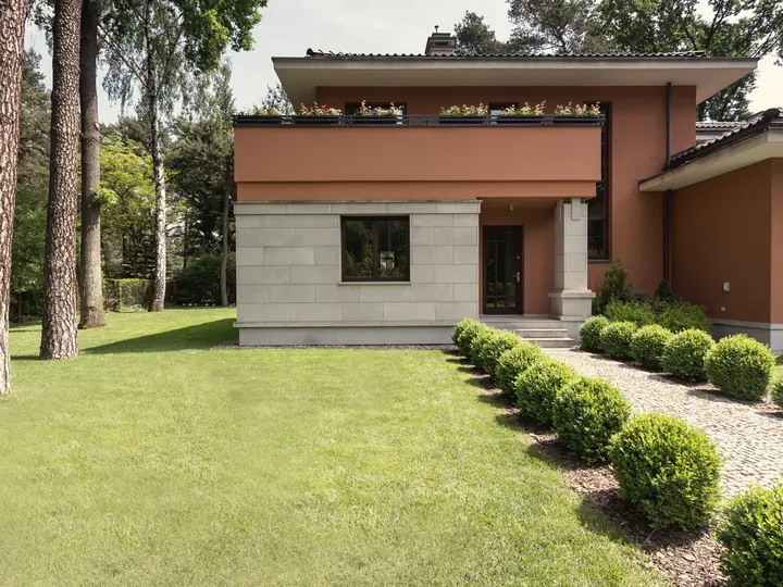 Maison contemporaine avec aménagement paysager haut de gamme : haies taillées et pelouse impeccable
