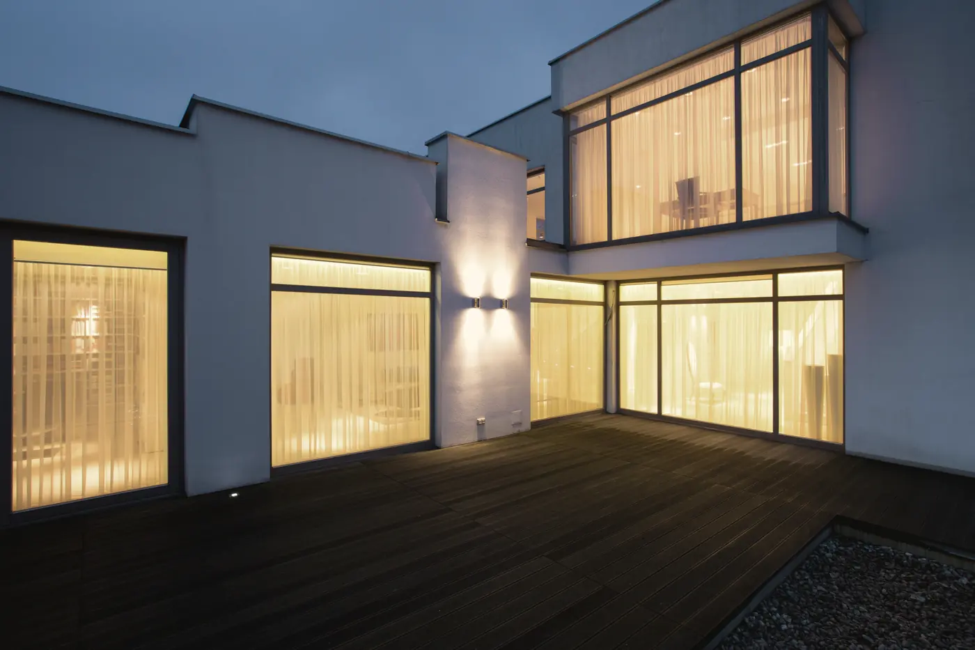 Maison moderne aux grandes fenêtres éclairées au crépuscule