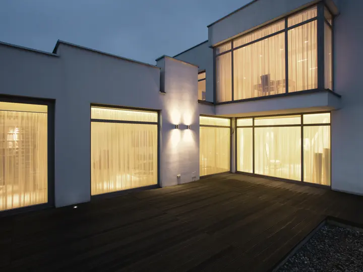 Maison moderne aux grandes fenêtres éclairées au crépuscule