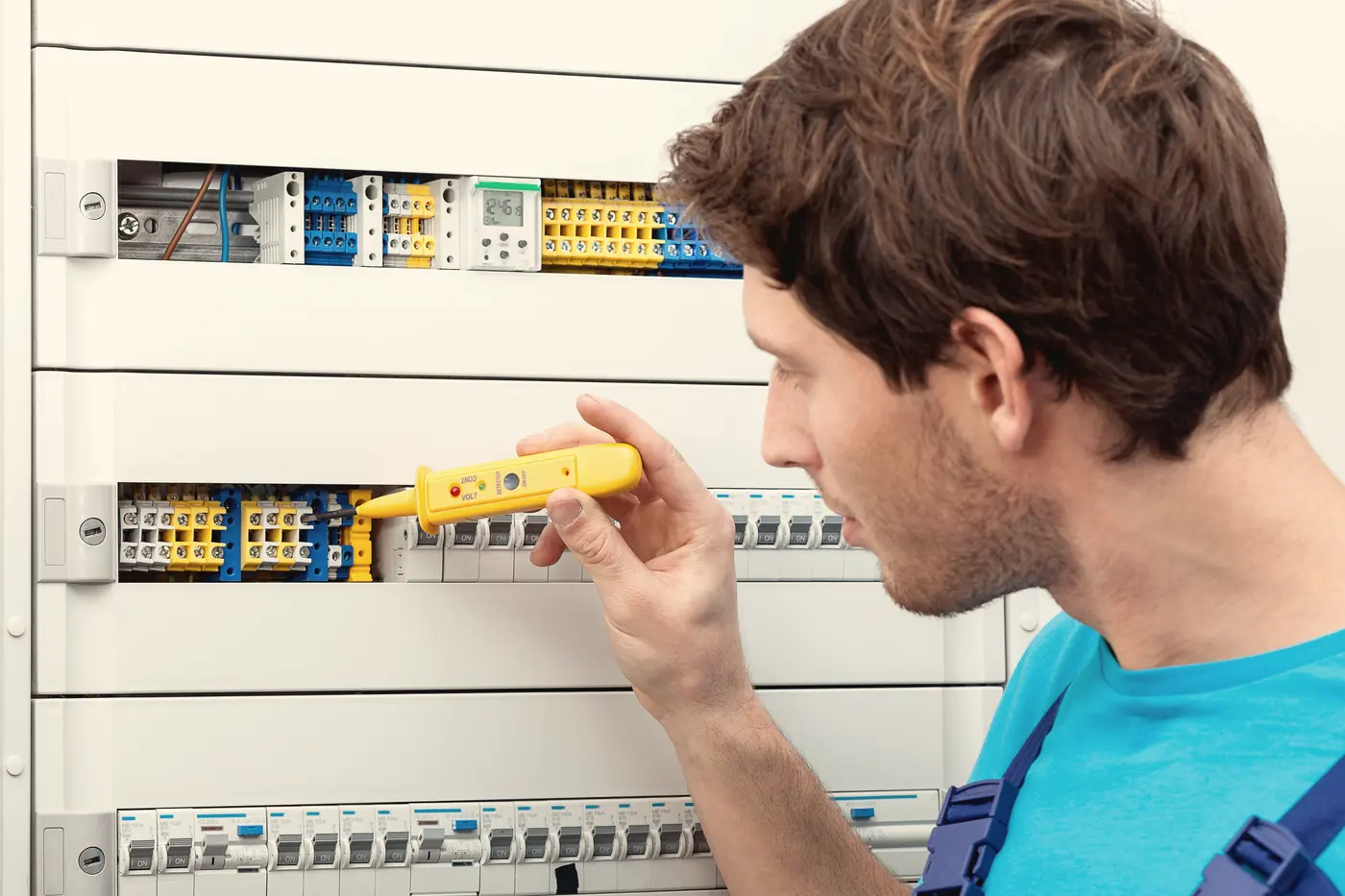 Électricien vérifiant un panneau de disjoncteurs